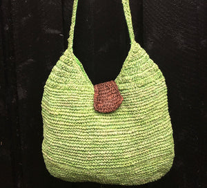 Limgrön flätad väska i bast med brun detalj från kooperativ